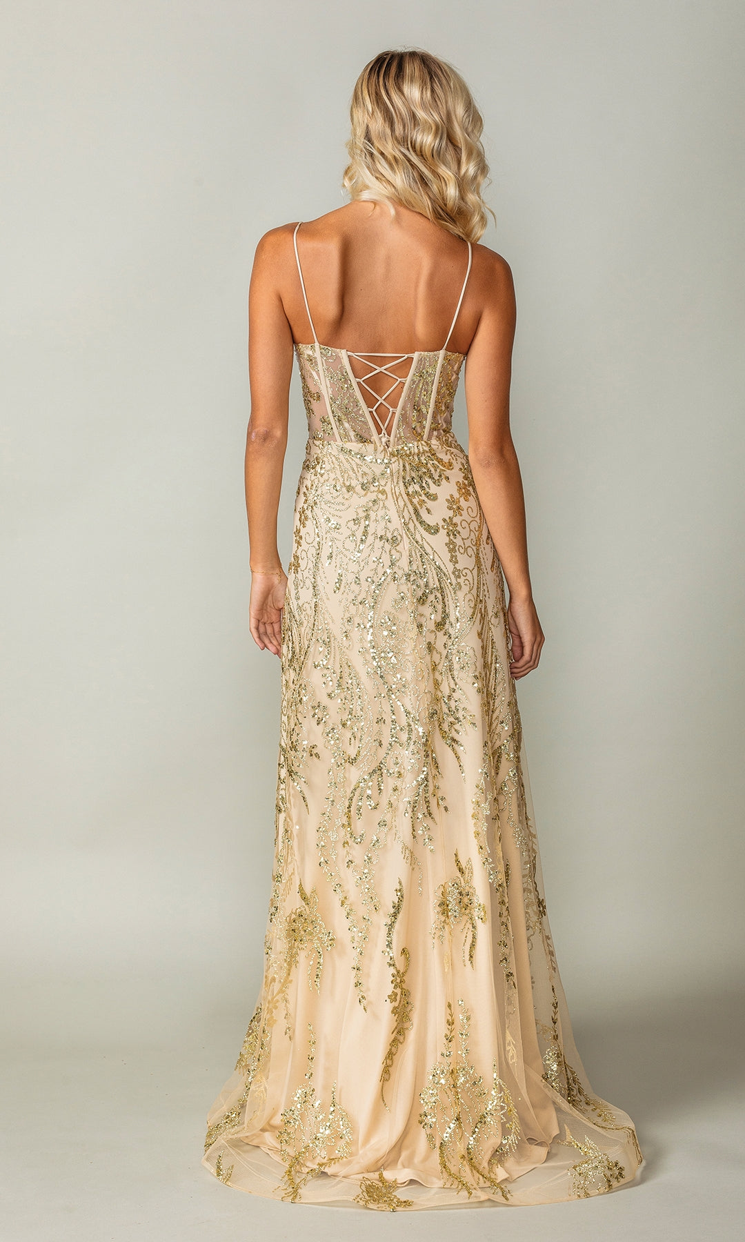 Woman facing away, wearing the Glitter-Print Long Prom Dress: Dancing Queen 4359—a floor-length gold and beige sequin gown featuring thin straps and a lace-up back.